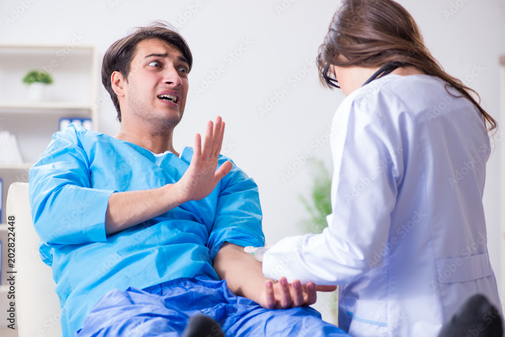 Obraz premium Scared patient man getting ready for flu shot