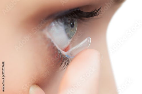 Extreme close up on young model applying contact lens