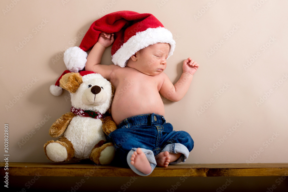 Newborn baby boy wearing a christmas hat and jeans, sleeping on a shelf next  to Teddy Bears Stock Photo | Adobe Stock