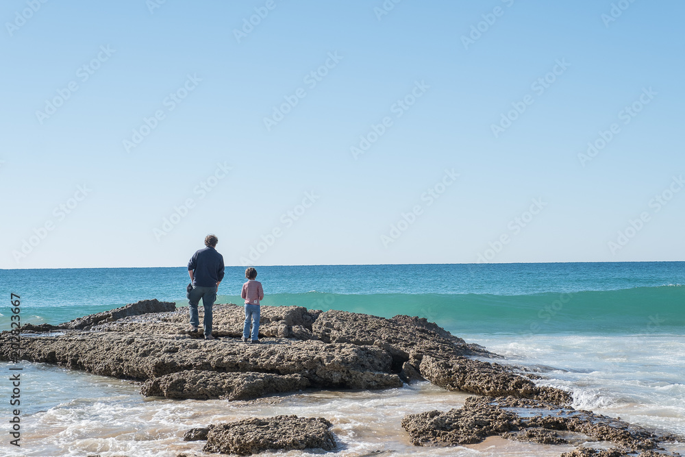 Padre y niño mirando el mar