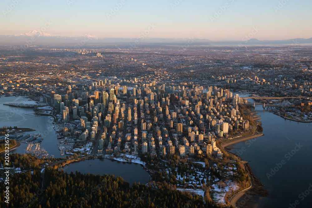 Naklejka premium Aerial view of Downtown City during a vibrant sunset. Taken in Vancouver, British Columbia, Canada.