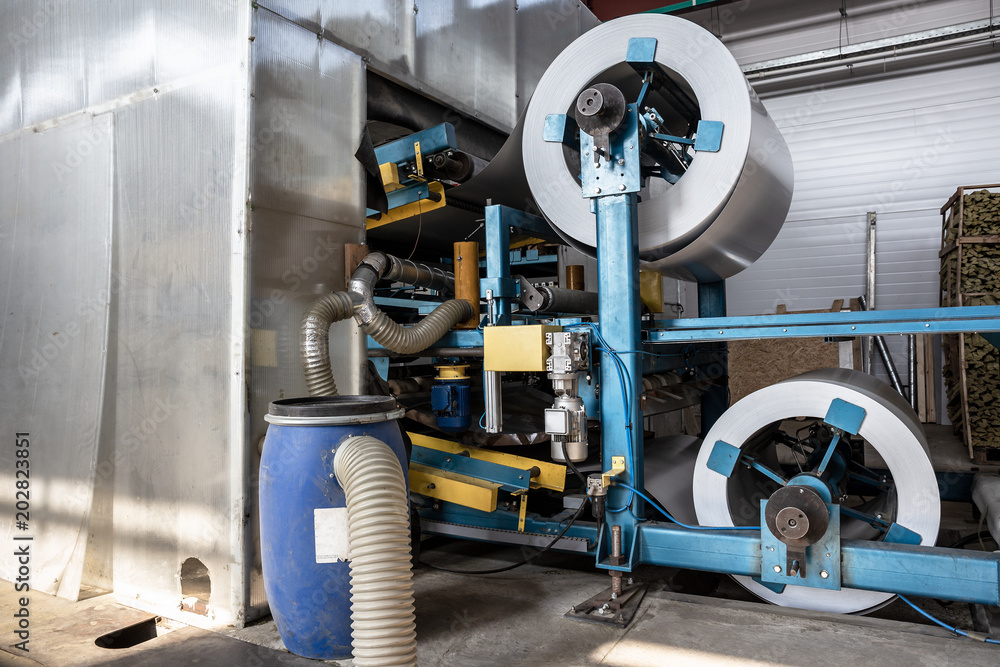 Naklejka premium Roll of galvanized steel or metal on machine in industrial workshop on rolling mill, manufacturing metalwork factory