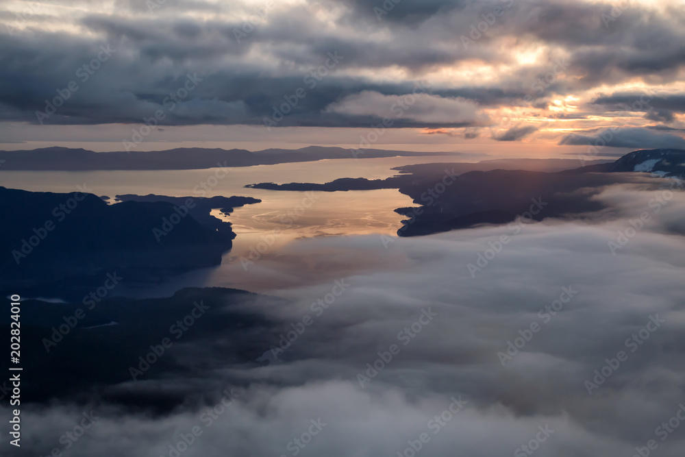Aerial landscape view of Sunshine Coast during a vibrant and dramatic sunset. Taken Northwest of Vancouver, British Columbia, Canada. Aerial landscape view of Sunshine Coast during a vibrant and dramatic sunset. Taken Northwest of Vancouver, British Columbia, Canada.