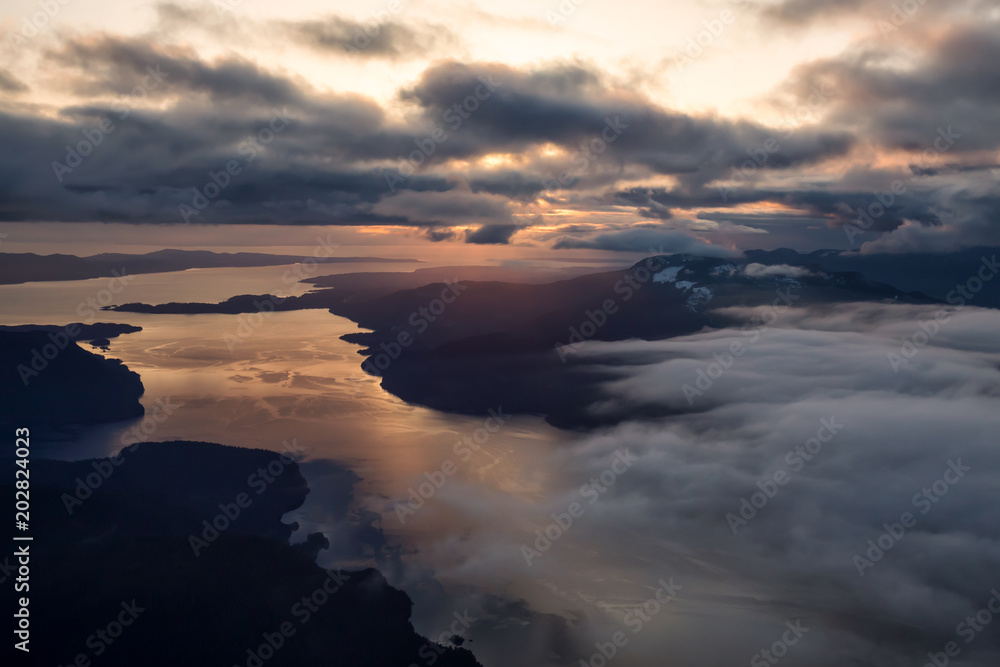 Aerial landscape view of Sunshine Coast during a vibrant and dramatic sunset. Taken Northwest of Vancouver, British Columbia, Canada. Aerial landscape view of Sunshine Coast during a vibrant and dramatic sunset. Taken Northwest of Vancouver, British Columbia, Canada.
