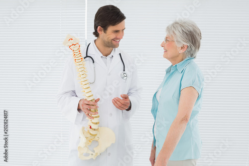 Male doctor explaining the spine to a senior patient