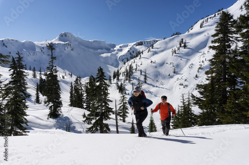 Adventurous man and woman are snowshoeing in the snow. Taken in Artist Point, Northeast of Seattle, Washington, United States of America.