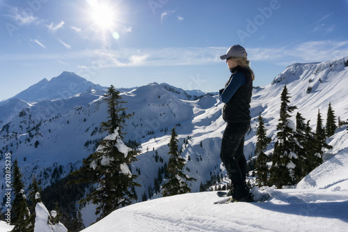 Adventurous woman is snowshoeing in the beautiful mountainous landscape. Taken in Artist Point, Northeast of Seattle, Washington, United States of America.