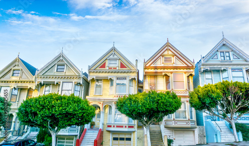 Late afternoon sun light up a row of colorful Victorian houses known as Painted Ladies across from Alamo Square. The historic houses were built between 1892 and 1896.