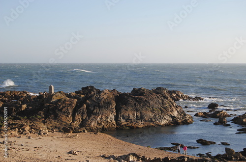 Uma praia, paisagem de costa marítima com uma praia e um rochedo grande photo