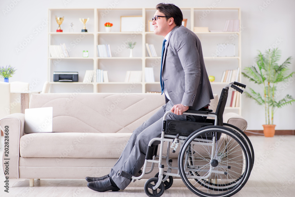 Dsabled businessman on wheelchair working home Dsabled businessman on wheelchair working home