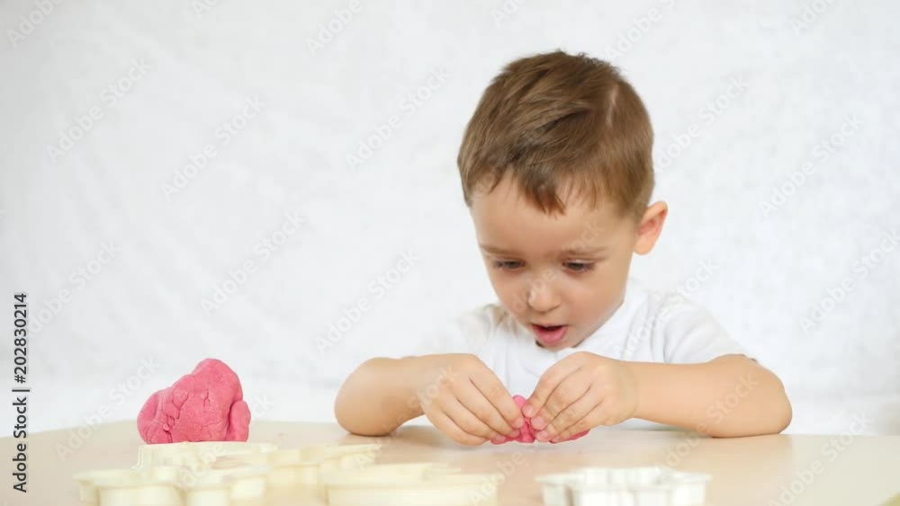 Children's creativity. The child with udovlstviem forms figures from the color test on the table. Cute children's plasticine figures on the table. Children's creativity. The child with udovlstviem forms figures from the color test on the table. Cute children's plasticine figures on the table.