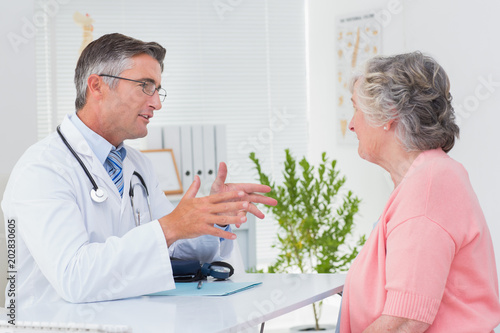 Fényképezés Male doctor conversing with female patient at table