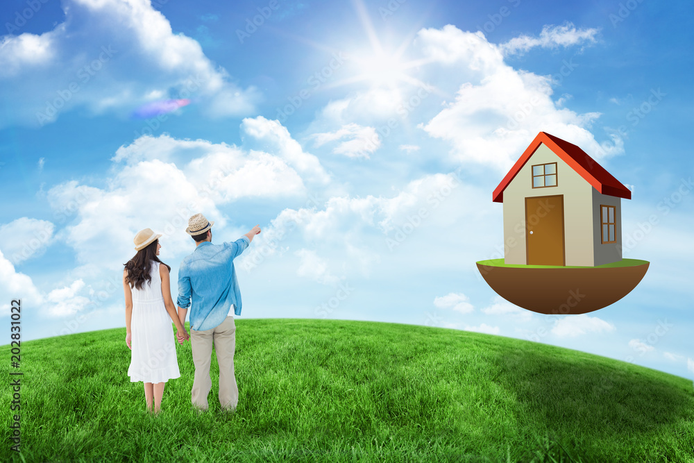 Happy hipster couple holding hands and looking against green hill under blue sky Happy hipster couple holding hands and looking against green hill under blue sky