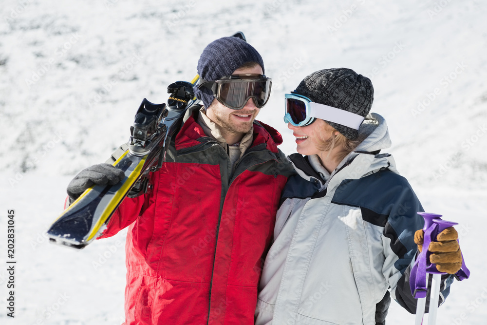 Happy young couple with ski boards on snow