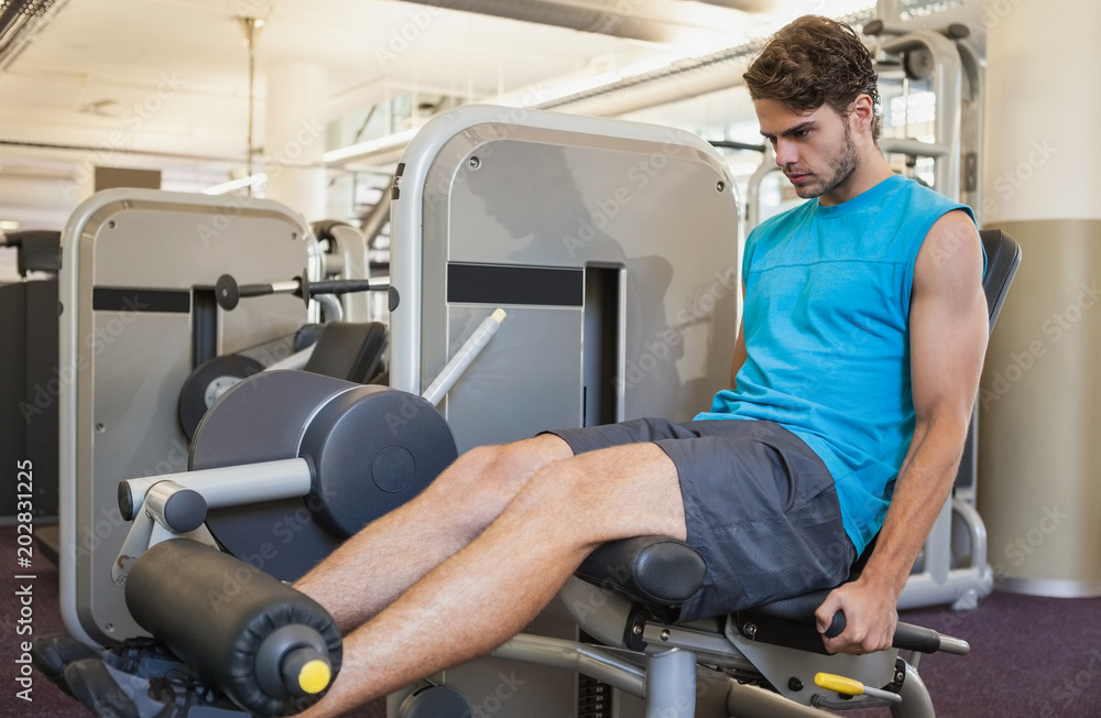 Focused man using weights machine for legs Focused man using weights machine for legs
