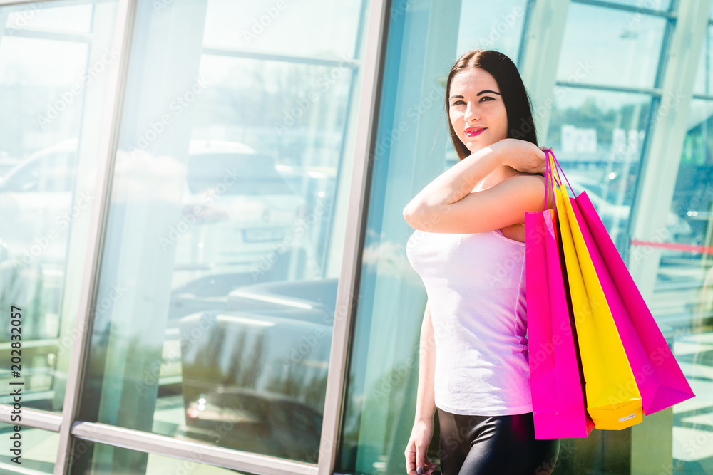 Happy and smiling girl enjoys shopping. Shopping concept. A young woman is satisfied with the things she bought. Female Walks or sit with Bags Full of Things She Bought. Happy and smiling girl enjoys shopping. Shopping concept. A young woman is satisfied with the things she bought. Female Walks or sit with Bags Full of Things She Bought.