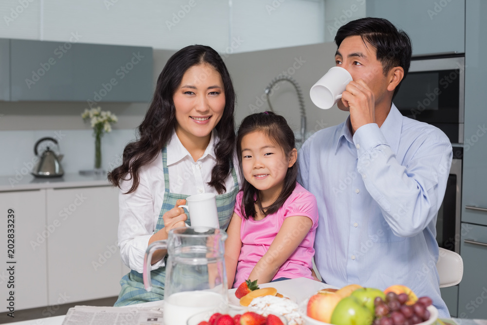 Portrait of a happy young girl enjoying breakfast with parents Portrait of a happy young girl enjoying breakfast with parents