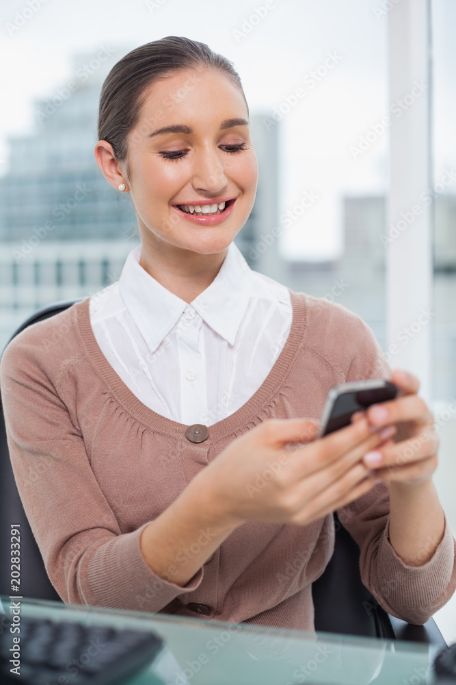 Obraz premium Smiling beautiful businesswoman text messaging
