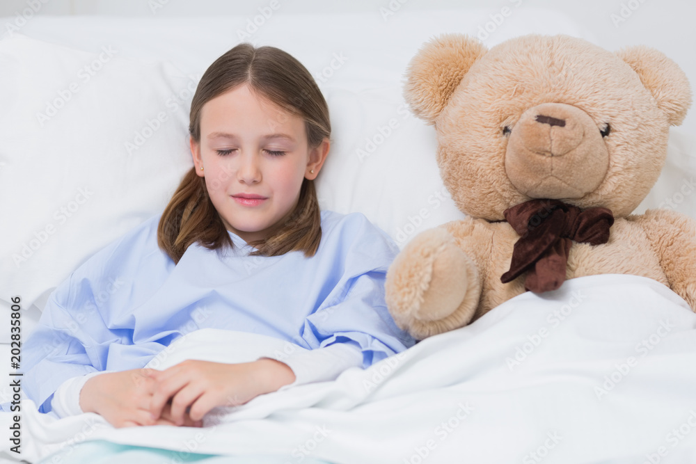 Child sleeping with a teddy bear while lying in a bed Child sleeping with a teddy bear while lying in a bed