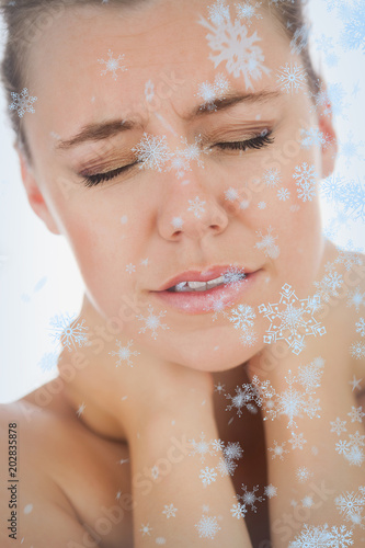 Woman with neck pain against snow falling