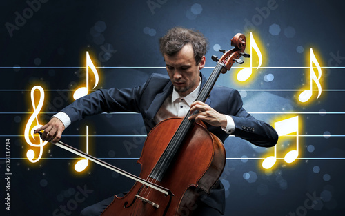 Young handsome cellist playing with music sheet background
