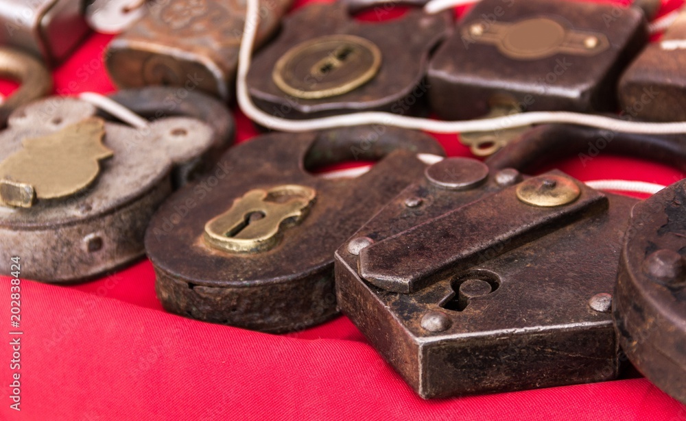 Antique padlocks on red shelf for sale at local market. Safety, locked concepts Antique padlocks on red shelf for sale at local market. Safety, locked concepts