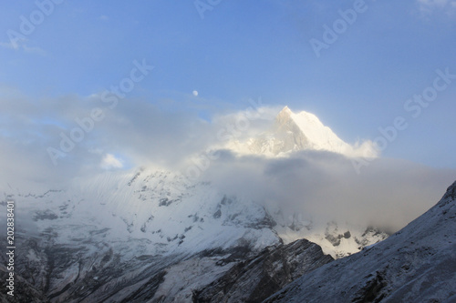 Annapurna Mountain Range with snow at sunrise in Annapurna Mountain Range from the base camp in Nepal. Fog, unclear, risk, dangerous, doubt concepts