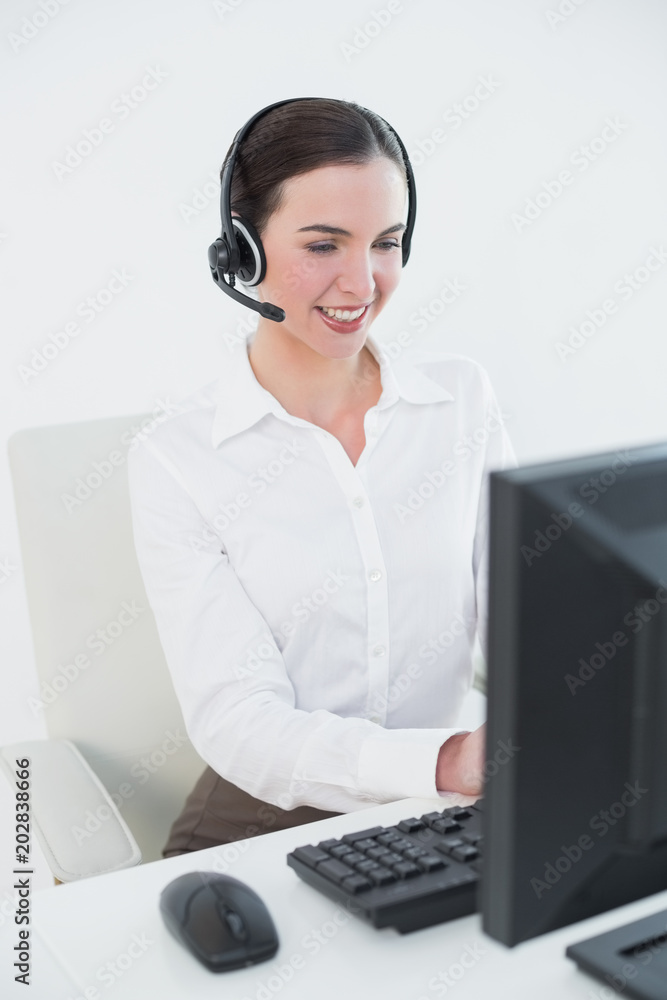 Businesswoman wearing headset while using computer