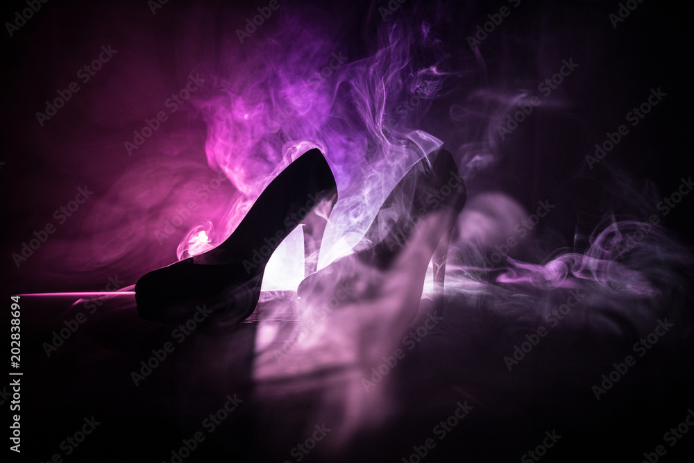 Φωτογραφία Black suede high heel women shoes on dark toned foggy background