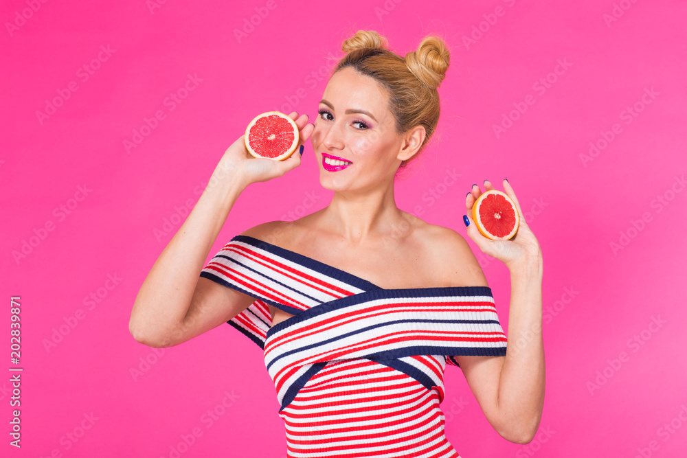 Great food for a healthy lifestyle. Beautiful young woman holding piece of orange against pink background Great food for a healthy lifestyle. Beautiful young woman holding piece of orange against pink background