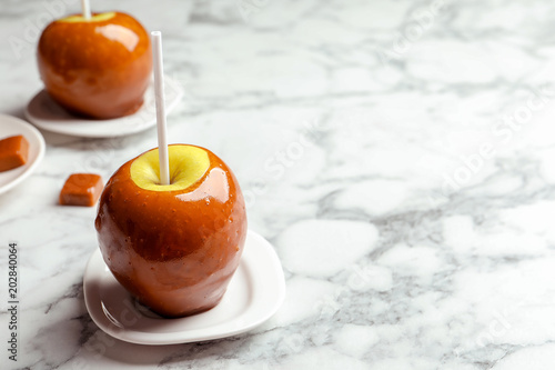 Delicious green caramel apple on marble table