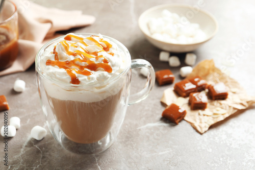Slika na platnu Cup of coffee with caramel topping on grey background