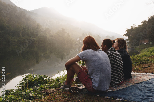 Group of friends sitting by lake