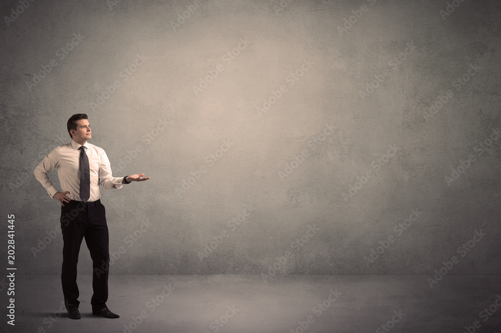 Caucasian businessman standing in front of a grunge, blank wall Caucasian businessman standing in front of a grunge, blank wall