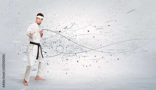 Young karate trainer doing karate tricks with chaotic concept 