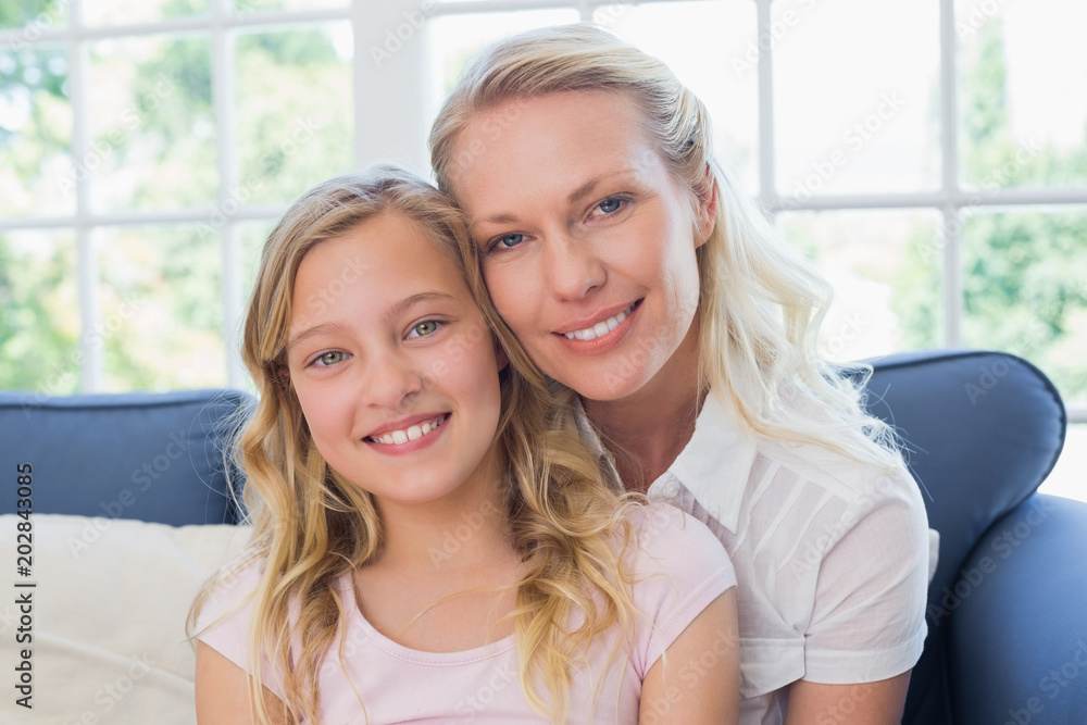 Happy mother and daughter sitting on sofa Happy mother and daughter sitting on sofa