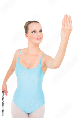Smiling pretty ballerina posing looking at her hand