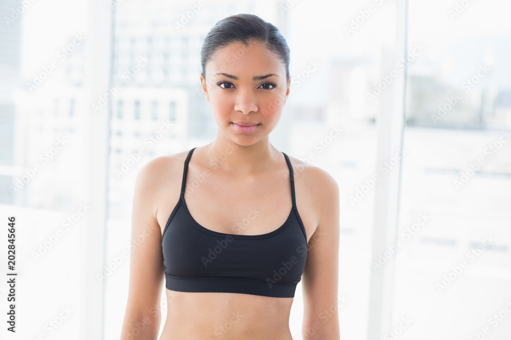 Serious dark haired model in sportswear posing looking at camera