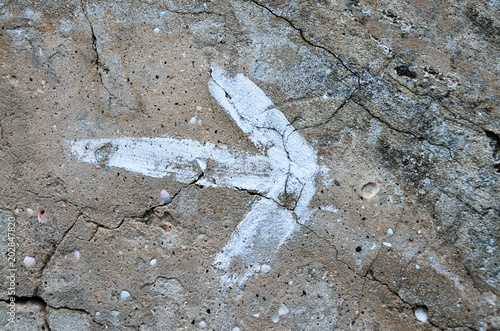 White arrow painted on the rock, to indicate the path.