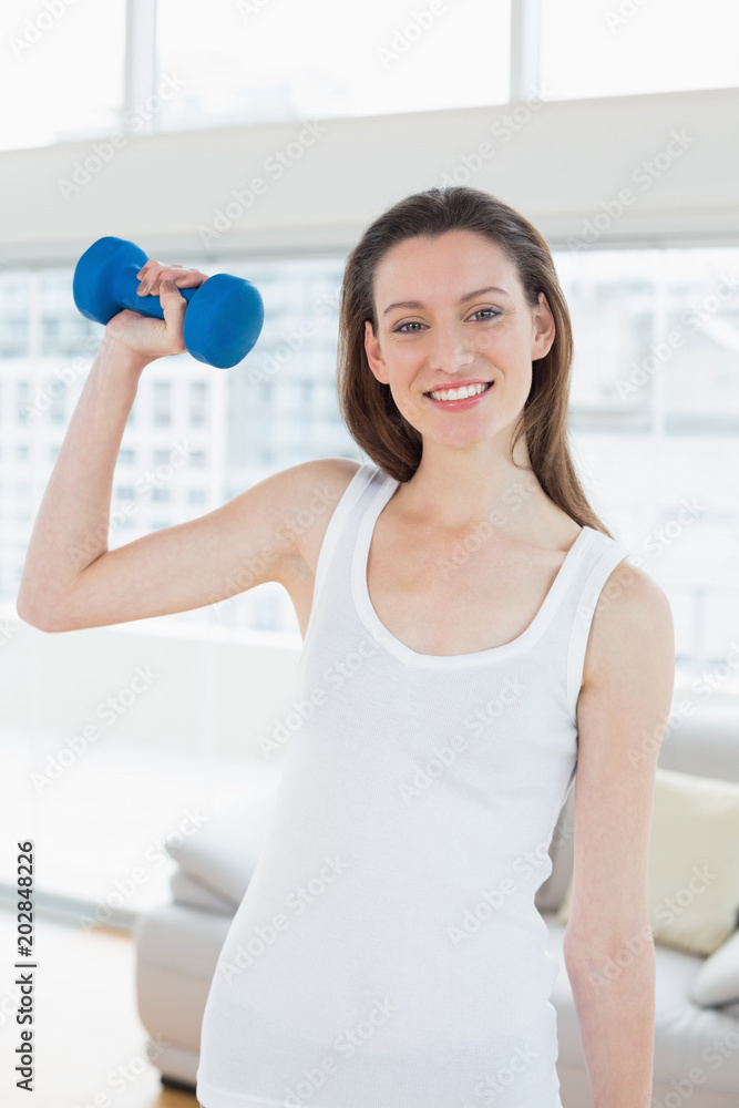 Fit woman exercising with dumbbell in fitness studio Fit woman exercising with dumbbell in fitness studio