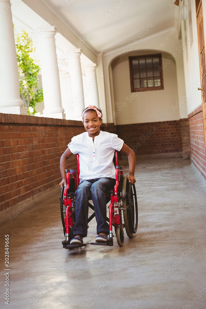 Girl sitting in wheelchair in school corridor Girl sitting in wheelchair in school corridor