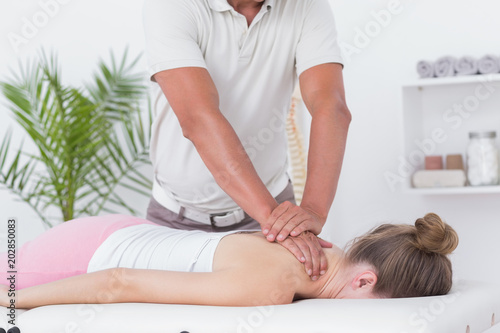 Physiotherapist doing neck massage to his patient