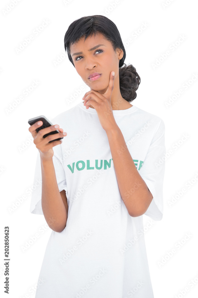 Thoughtful black haired volunteer holding a mobile phone Thoughtful black haired volunteer holding a mobile phone
