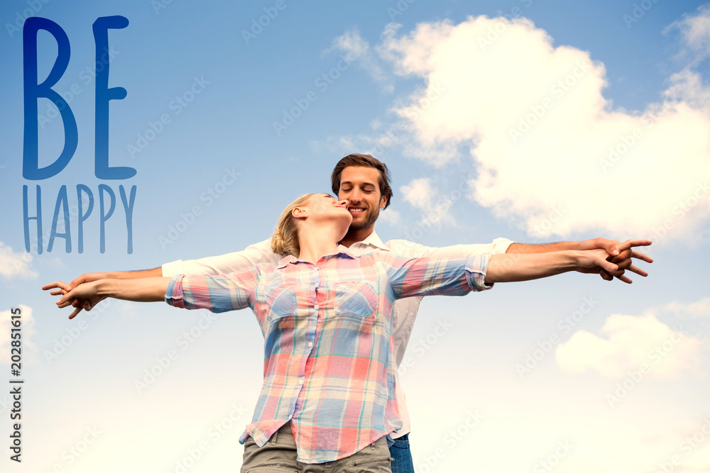 Happy couple standing outside with arms stretched kissing against be happy Happy couple standing outside with arms stretched kissing against be happy