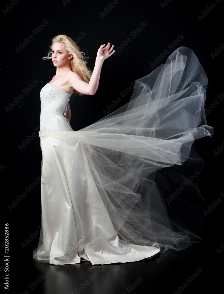 full length portrait of woman wearing white bridal gown. standing poison black studio background. full length portrait of woman wearing white bridal gown. standing poison black studio background.