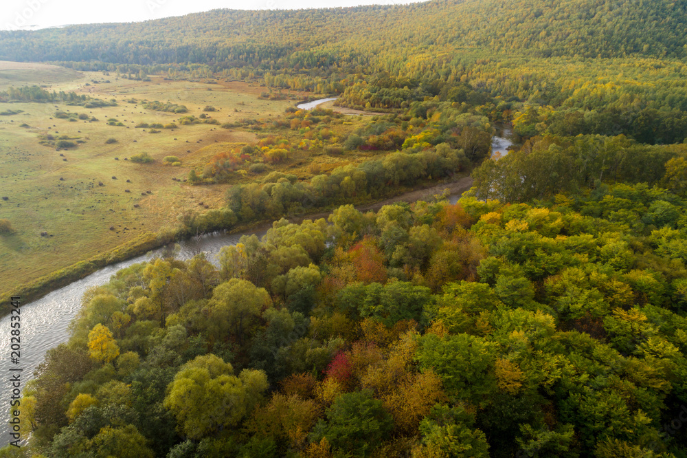 Aerial drone View of autumn mountains and small river with forests in sunrise soft light. Majestic landscape. Aerial drone View of autumn mountains and small river with forests in sunrise soft light. Majestic landscape.