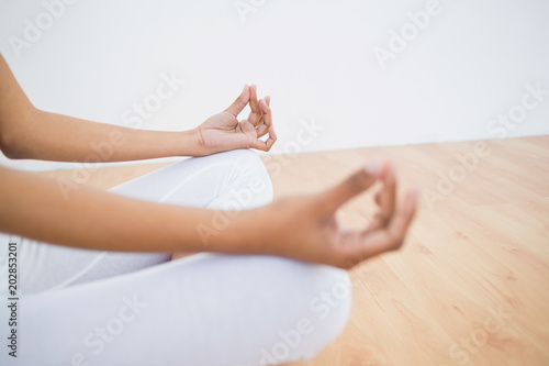 Mid section of slender young woman meditating 