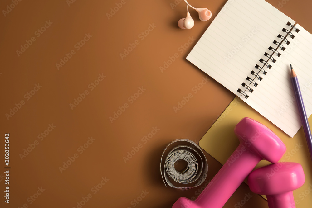 Φωτογραφία Styled stock photography of fitness equipment dumbbells notepad pencil and earphone on brown background