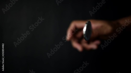 slowmotion shot tossing coin to flip on heads or tails