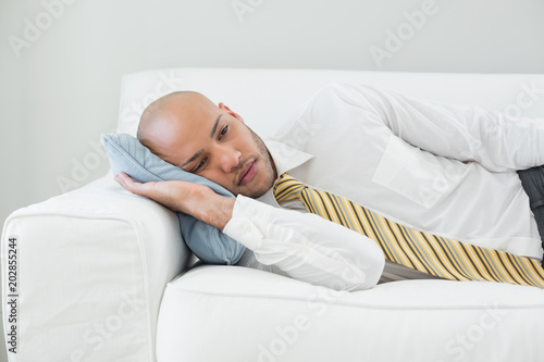 Businessman resting on sofa at home